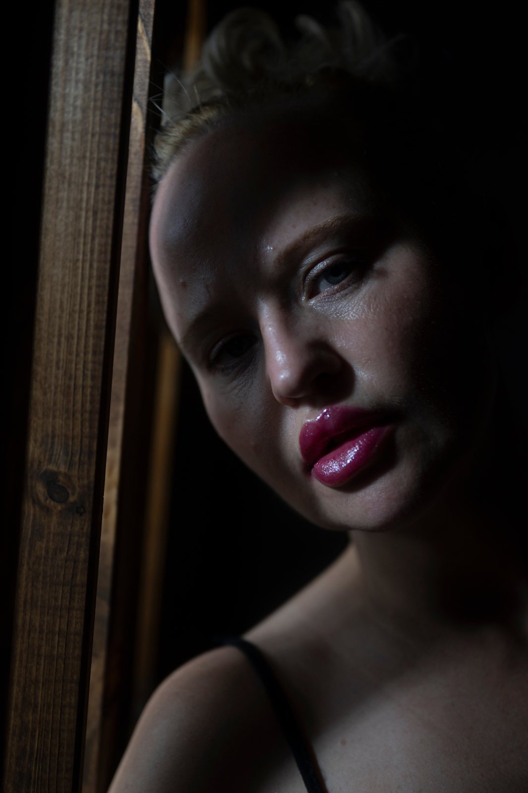Why This Portrait Is Almost Black – How a Fine Art Portrait Was Created with the Nikon Z9 Fine Art portrait photographed with a Nikon Z9, NIKKOR Z 50mm f/1.8 S and Godox AD300 Pro using dramatic light through wooden panels.