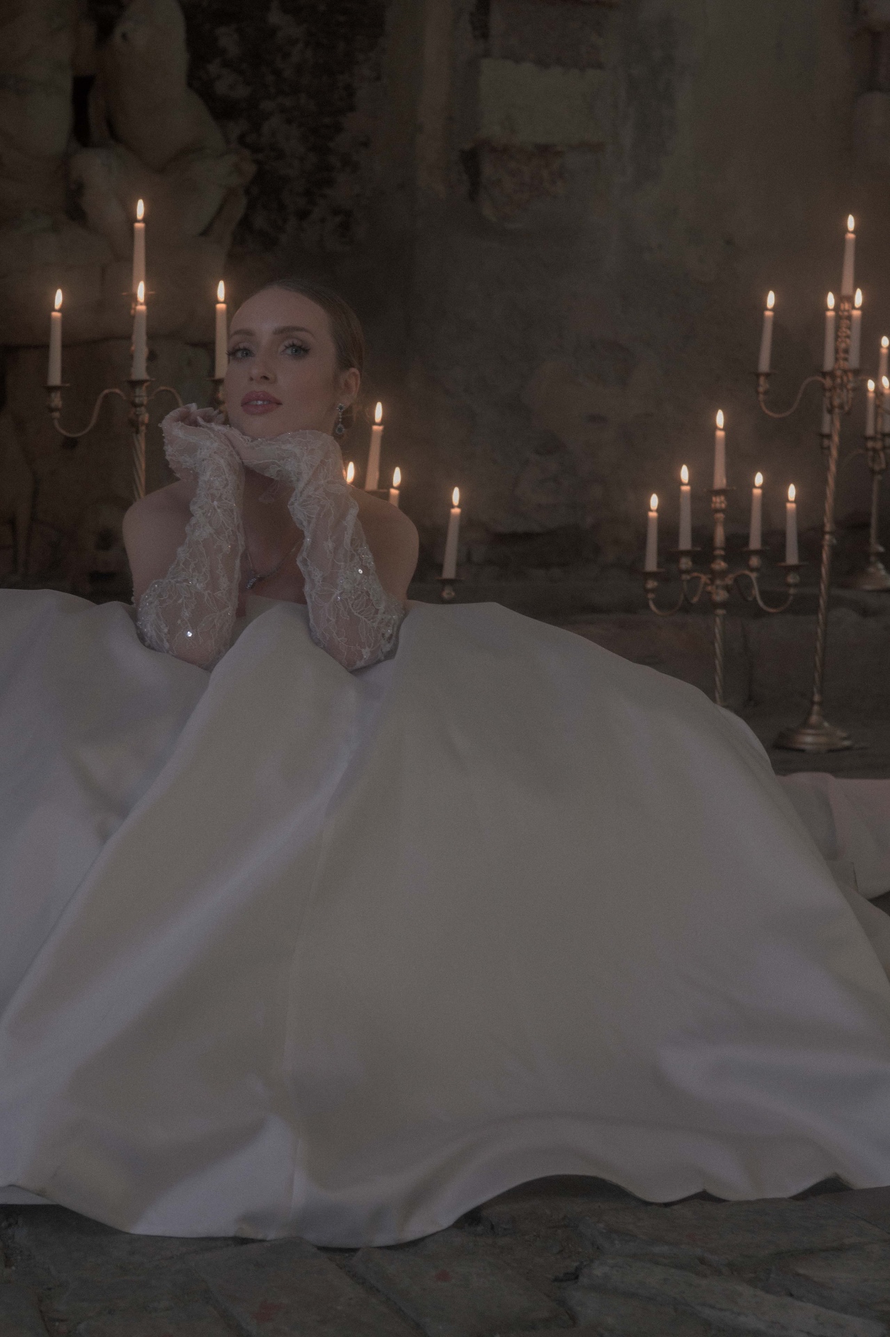 Bride in soft candlelight with lace gloves