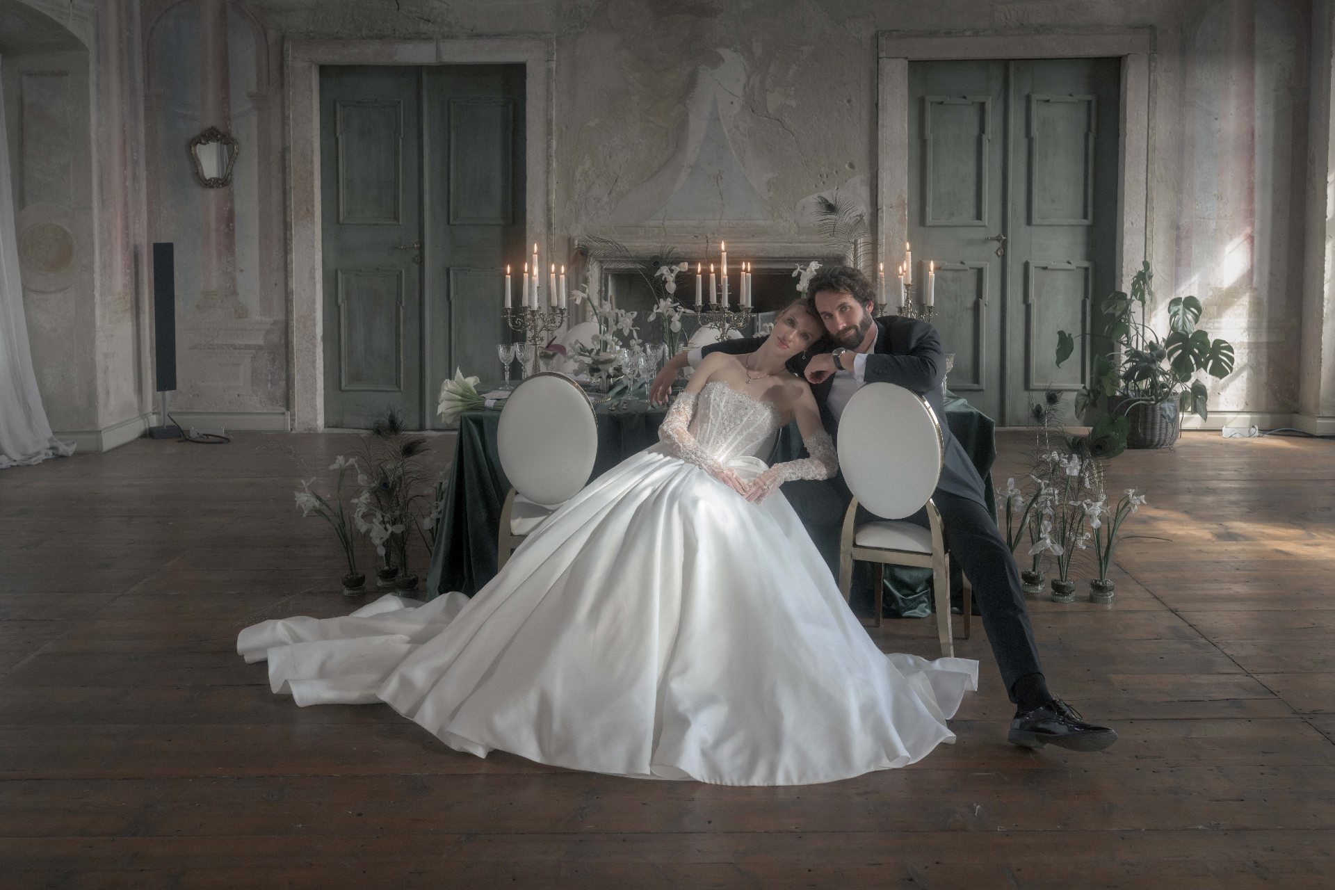 Bride and groom seated together in a castle ballroom