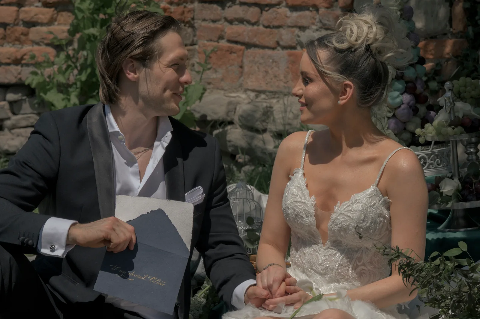 Bride and groom framed by old stone walls and soft foliage in a quiet editorial wedding portrait at Schloss Haggenberg.