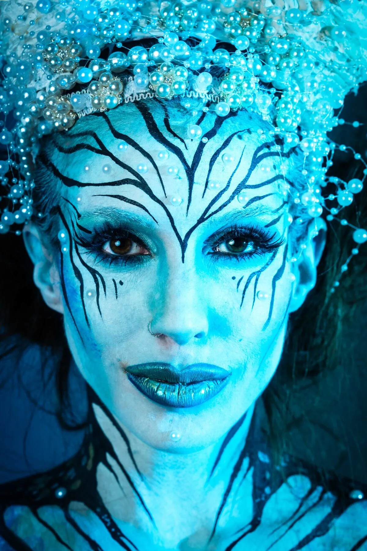 Close-up fine-art bodypainting photography - metallic blue face portrait cinematic lighting NIKKOR 135mm Plena