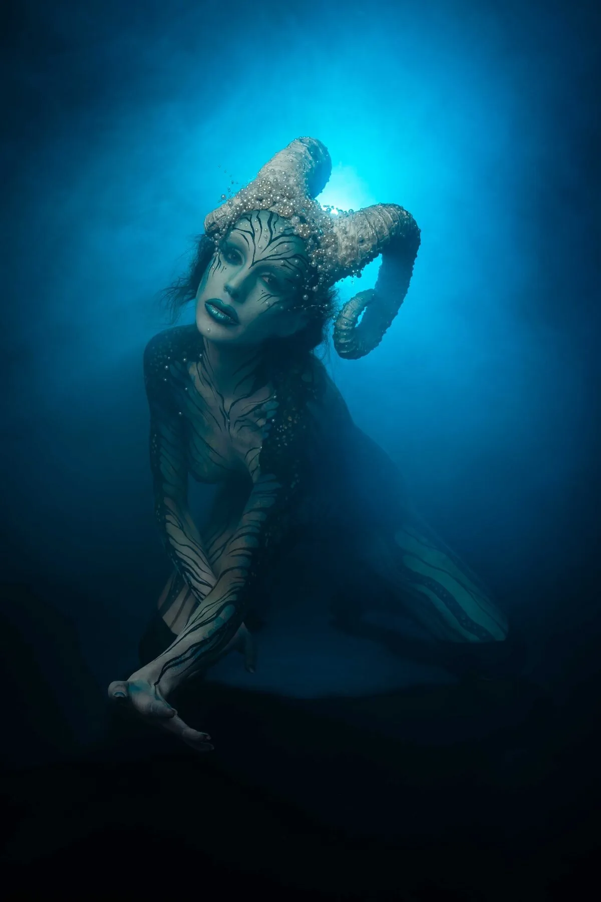 Otherworldly editorial portrait photography - intricate custom headpiece blue metallic bodypainting Vienna photographer