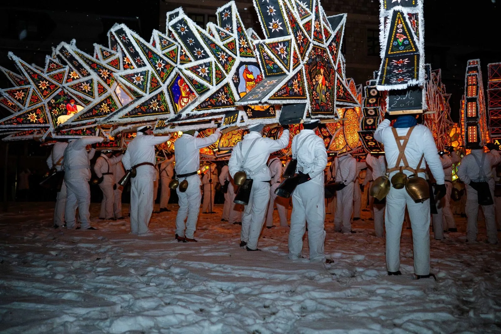 Glöckler Passe in Formation am Buchberg mit leuchtenden Dreiecks-Kappen im Schnee bei Nacht