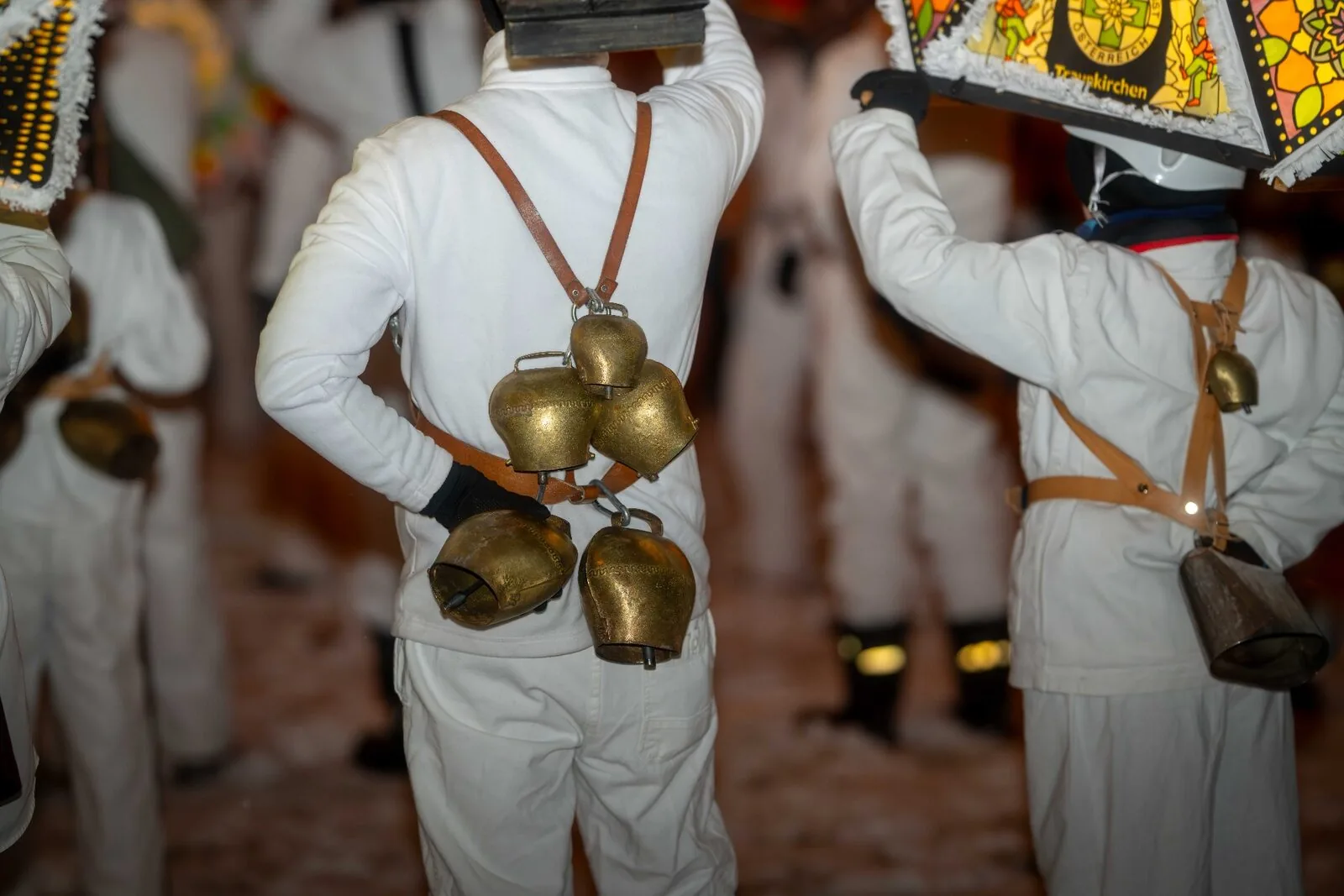Detailaufnahme der traditionellen Glocken am Rücken eines Glöcklers - messingfarbene Schellen