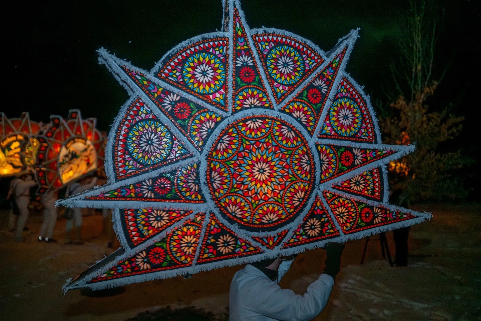 Farbenfrohe sternförmige Glöcklerkappe mit Mandala-Muster in Nachtszene