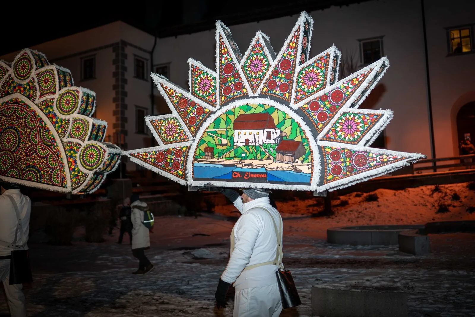 Glöckler mit sonnenförmiger Kappe zeigt traditionelles Eisenau-Motiv im Schnee