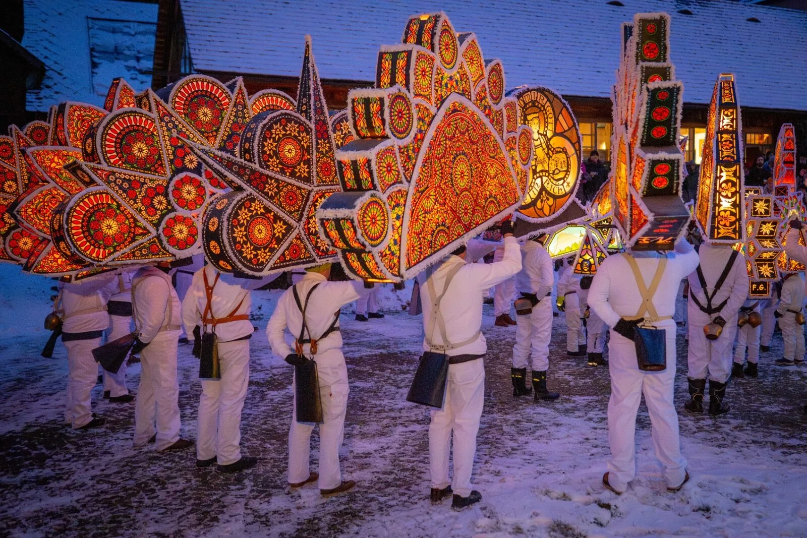 Gruppe von Glöcklern mit bunten leuchtenden Kappen verschiedener Formen im Schnee