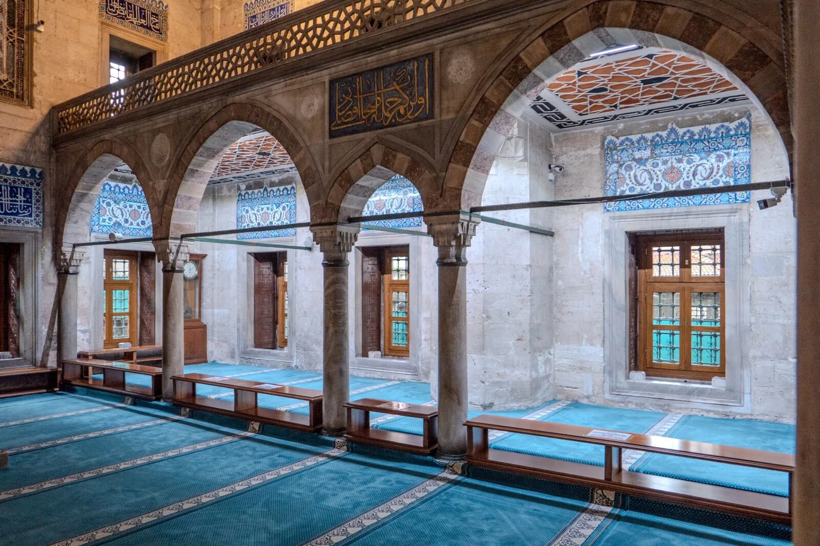 Sokollu Mehmed Pasha Mosque interior arches with turquoise carpet Iznik tiles and wooden benches