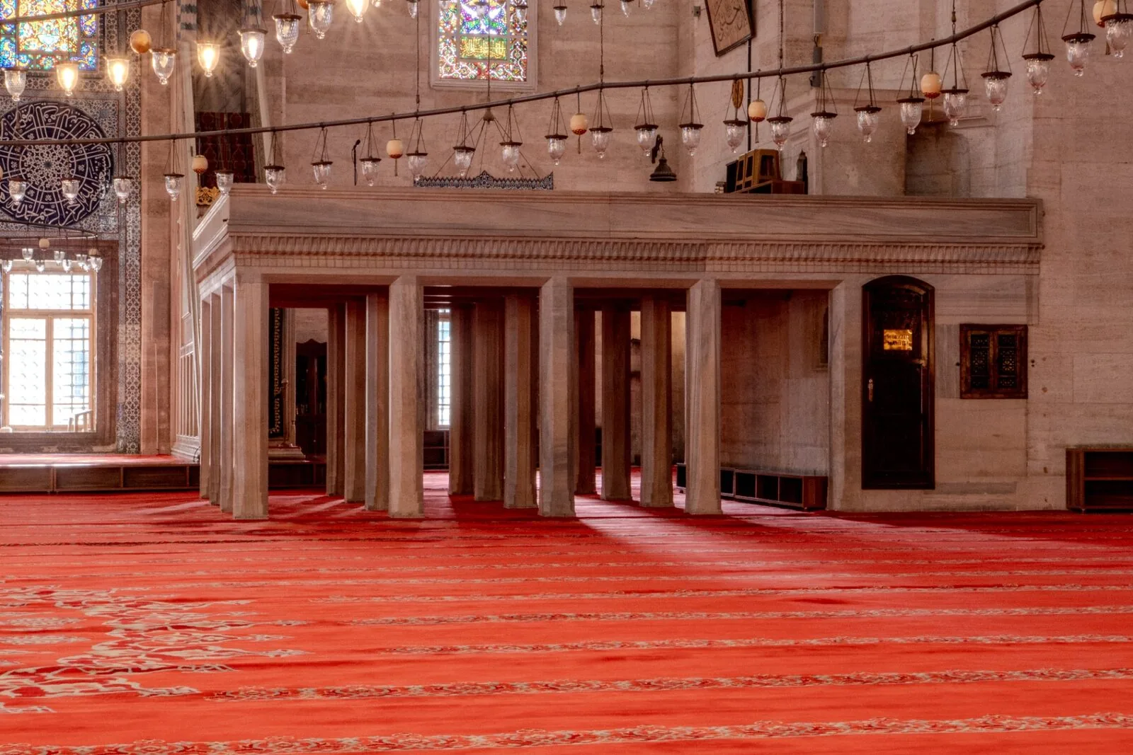 Süleymaniye prayer hall interior with red carpet mihrab and natural light from windows