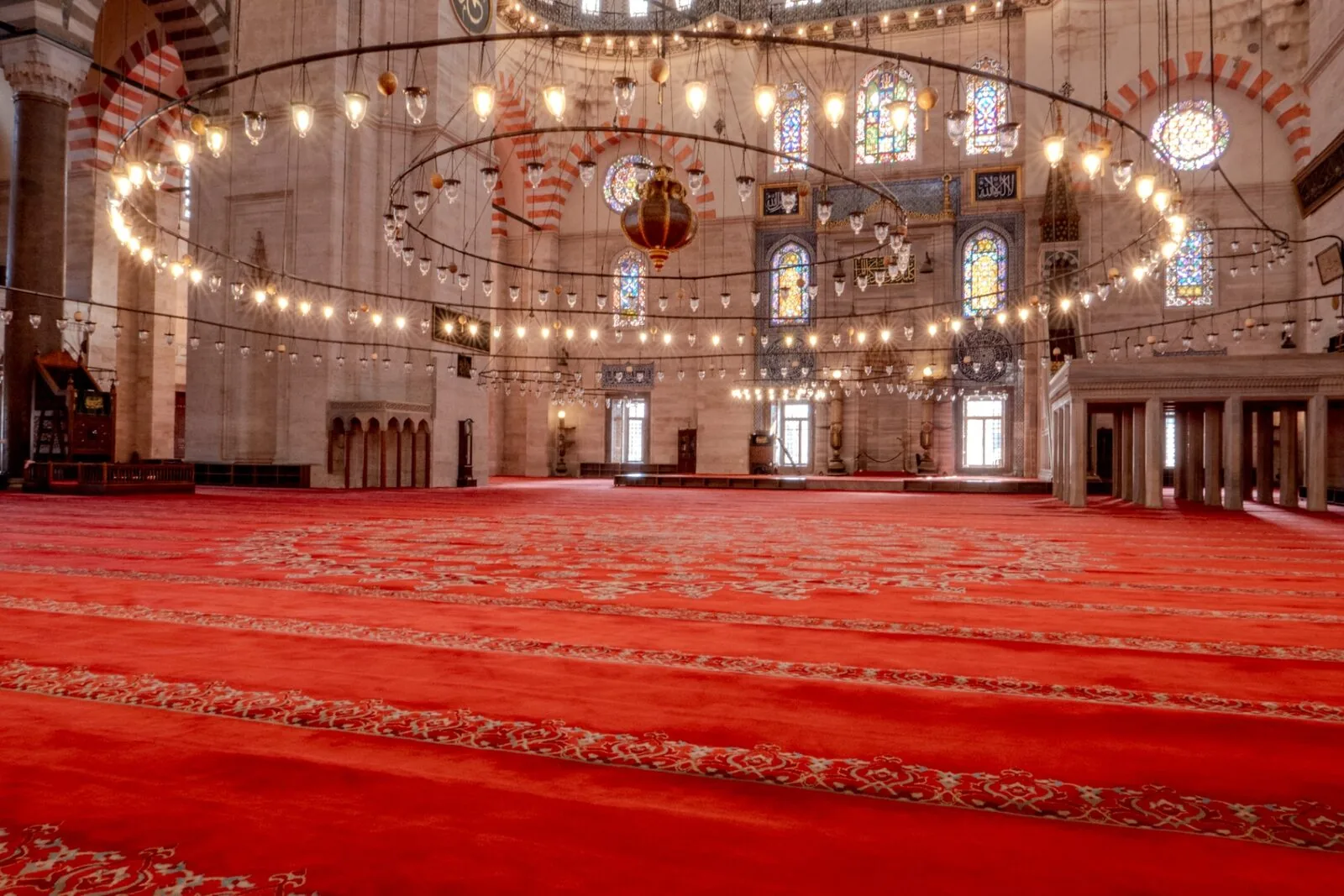 Süleymaniye central dome interior with hanging chandeliers stained glass windows calligraphy