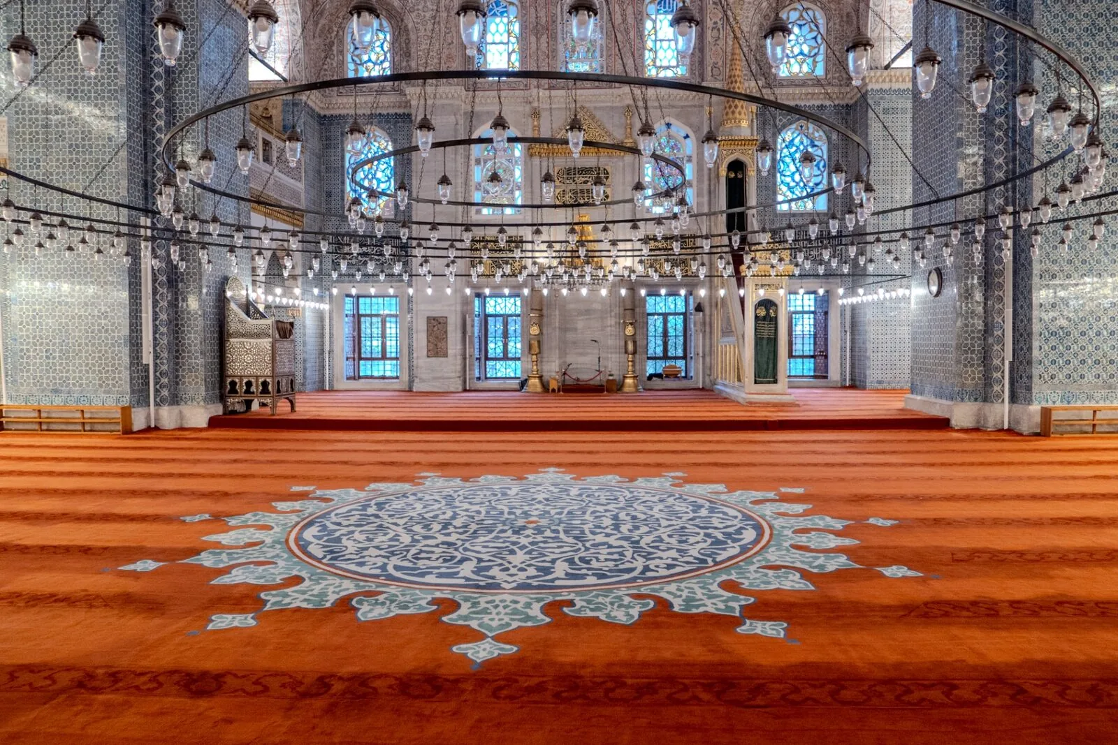 Yeni Cami New Mosque Istanbul prayer hall interior with turquoise carpet Iznik tile walls and hanging medallions
