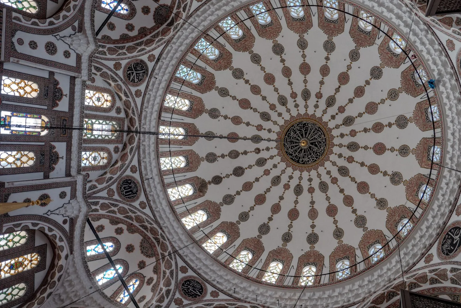 Yeni Valide dome ceiling with ornate painted decorations stained glass windows and calligraphy
