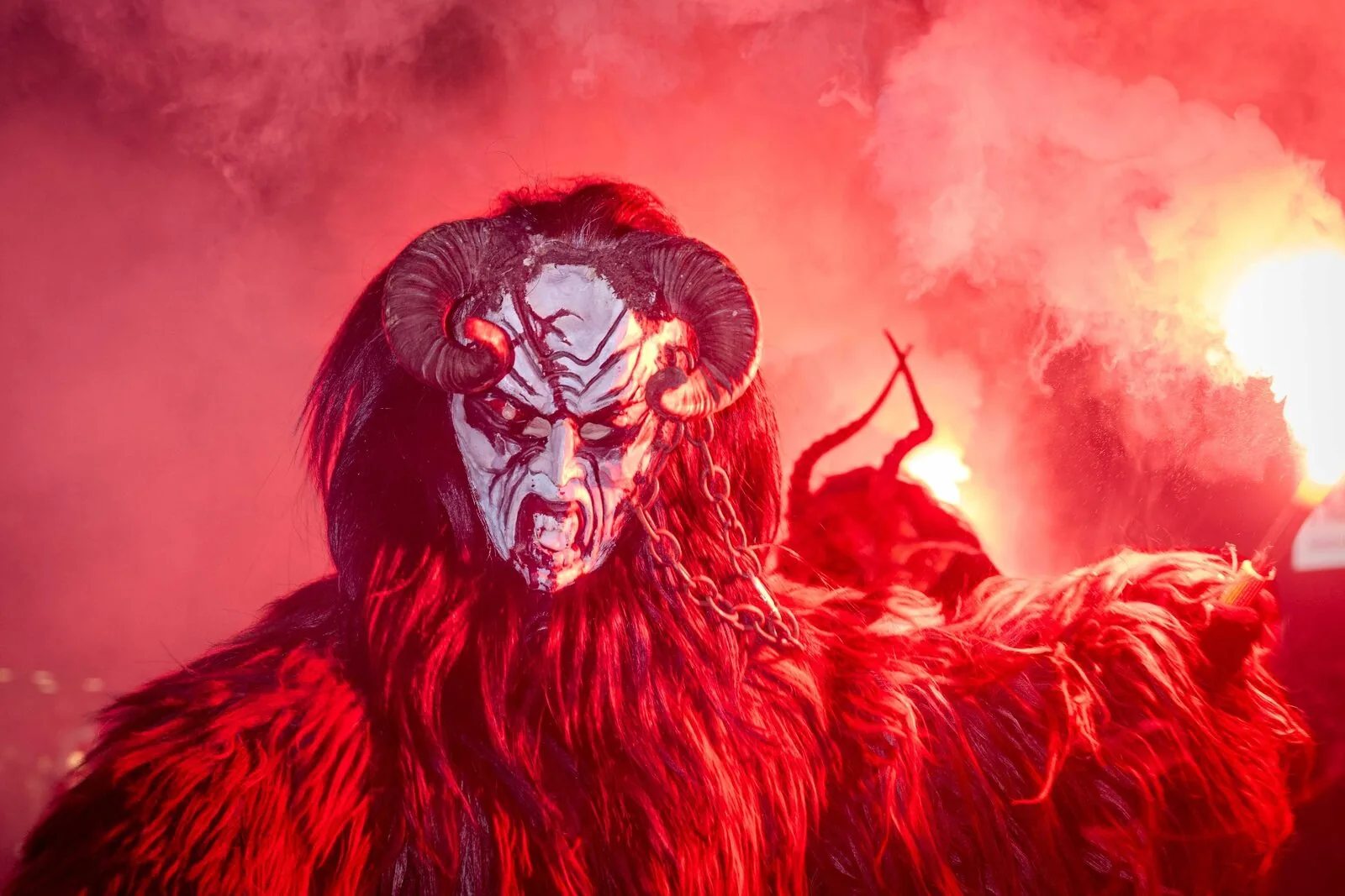 Krampus dämonische Figur dramatische Feuerbeleuchtung - Alpine Folklore Ritualfotografie Niederösterreich Peter Scholz