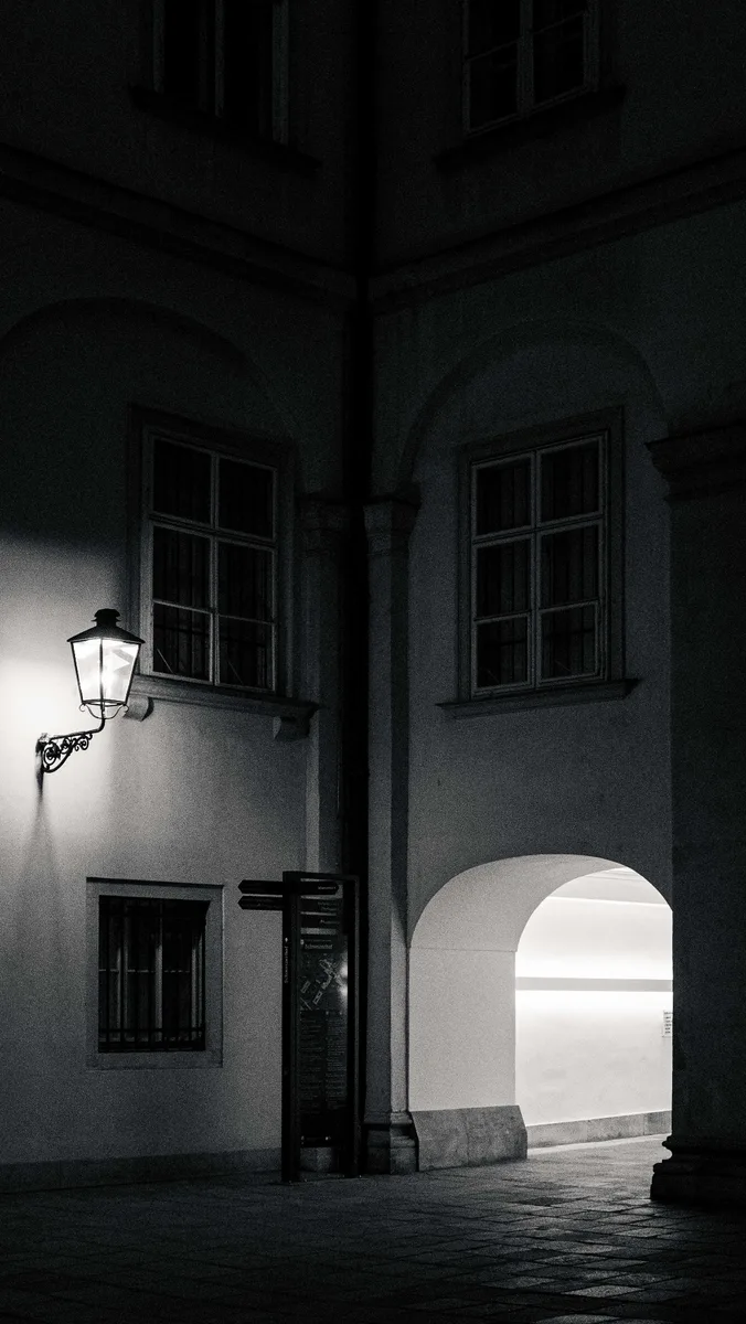 Vienna courtyard at night — black and white, wall lantern and illuminated archway, Leica D-LUX 8 by schopho