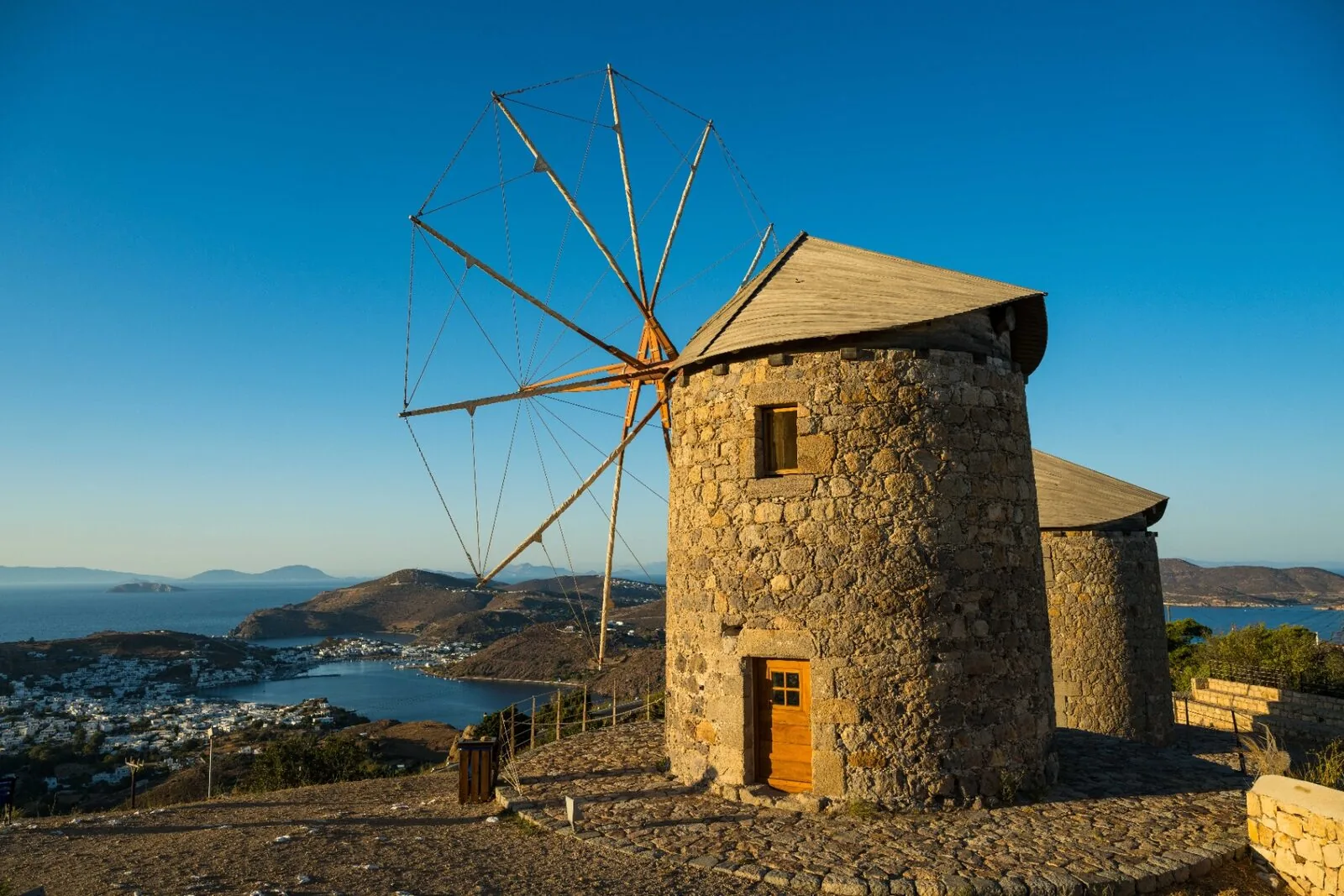 Traditional windmill overlooking Patmos harbor at golden hour