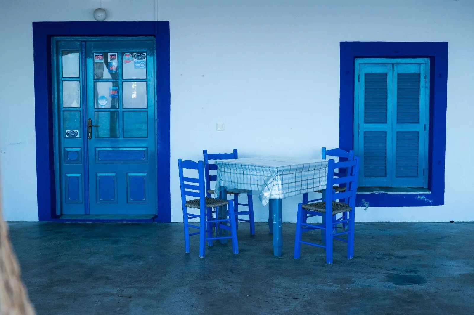 Blue painted traditional Greek door and outdoor table setting