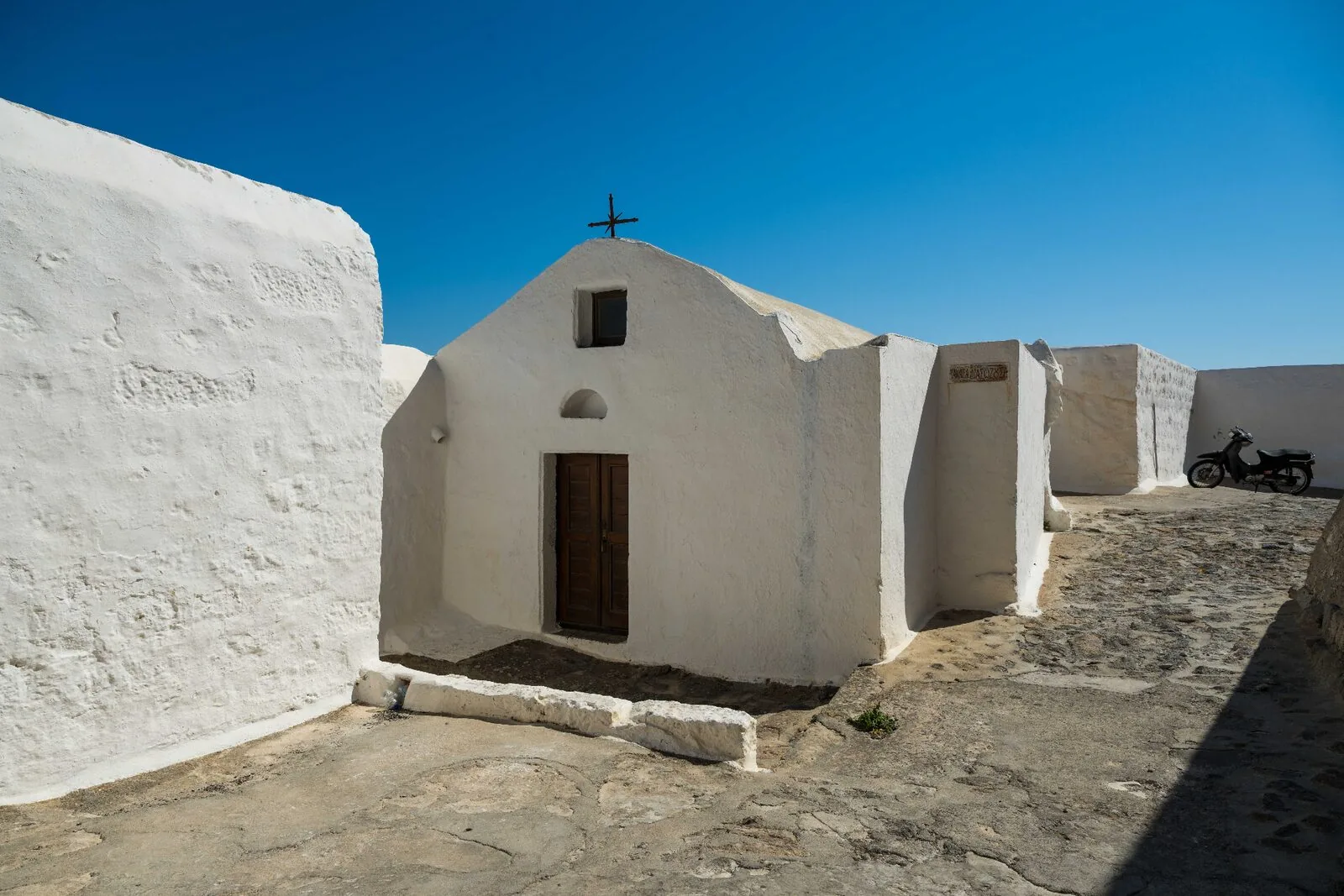 Small whitewashed chapel on rocky hillside in Patmos