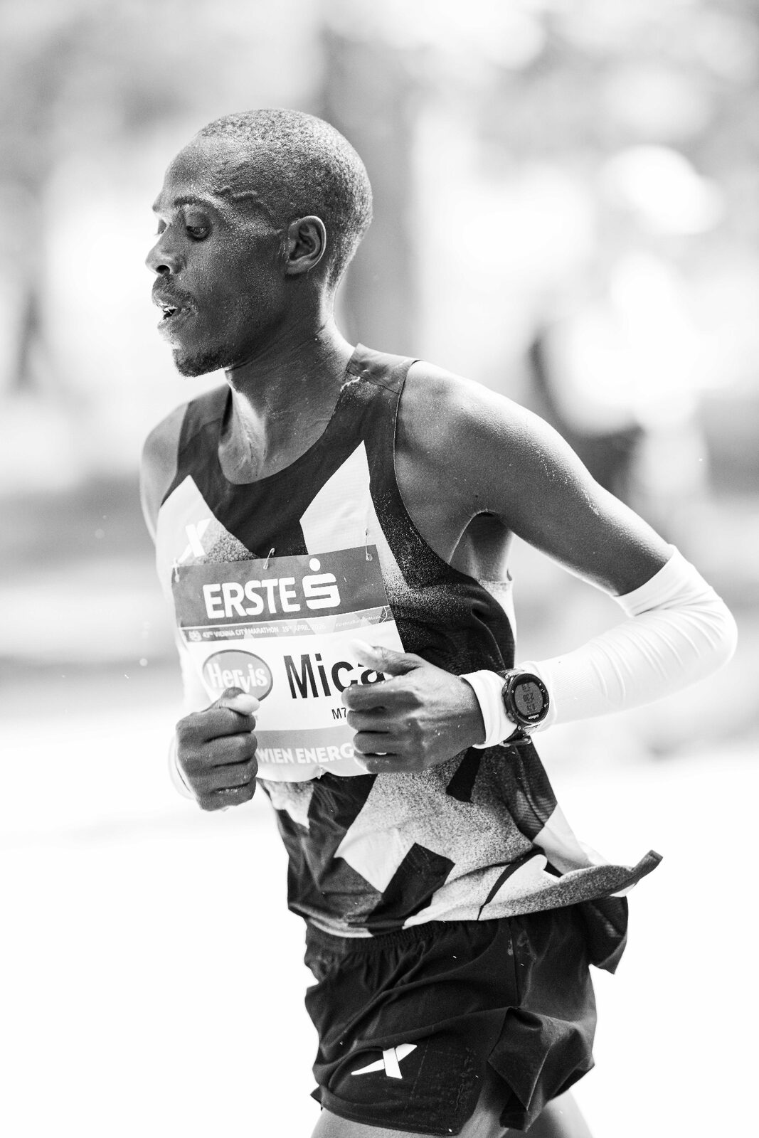 Marathon runner close-up portrait at kilometer 35 — exhaustion and willpower, NIKKOR Z 135mm Plena black and white photography by Peter Scholz
