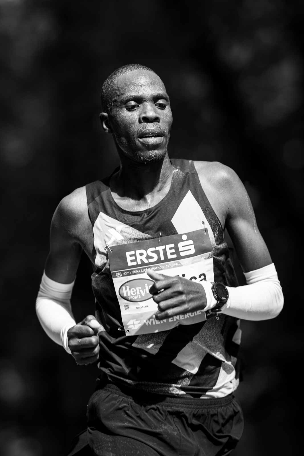 Elite marathon runner in concentration on the Prater Hauptallee — black and white portrait photography by schopho