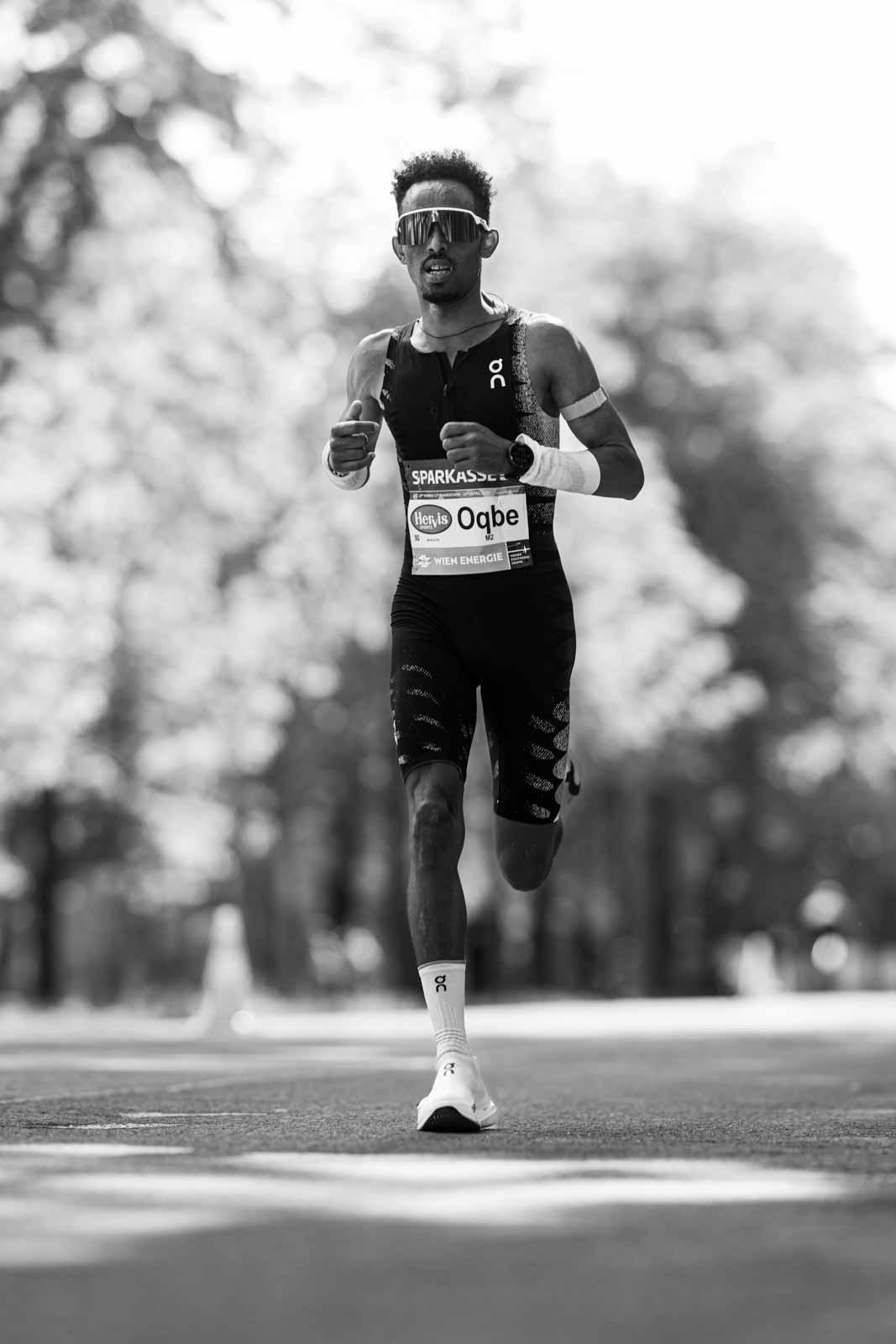 Marathon runner Oqbe running head-on through the Vienna Prater — black and white fine art photography by schopho