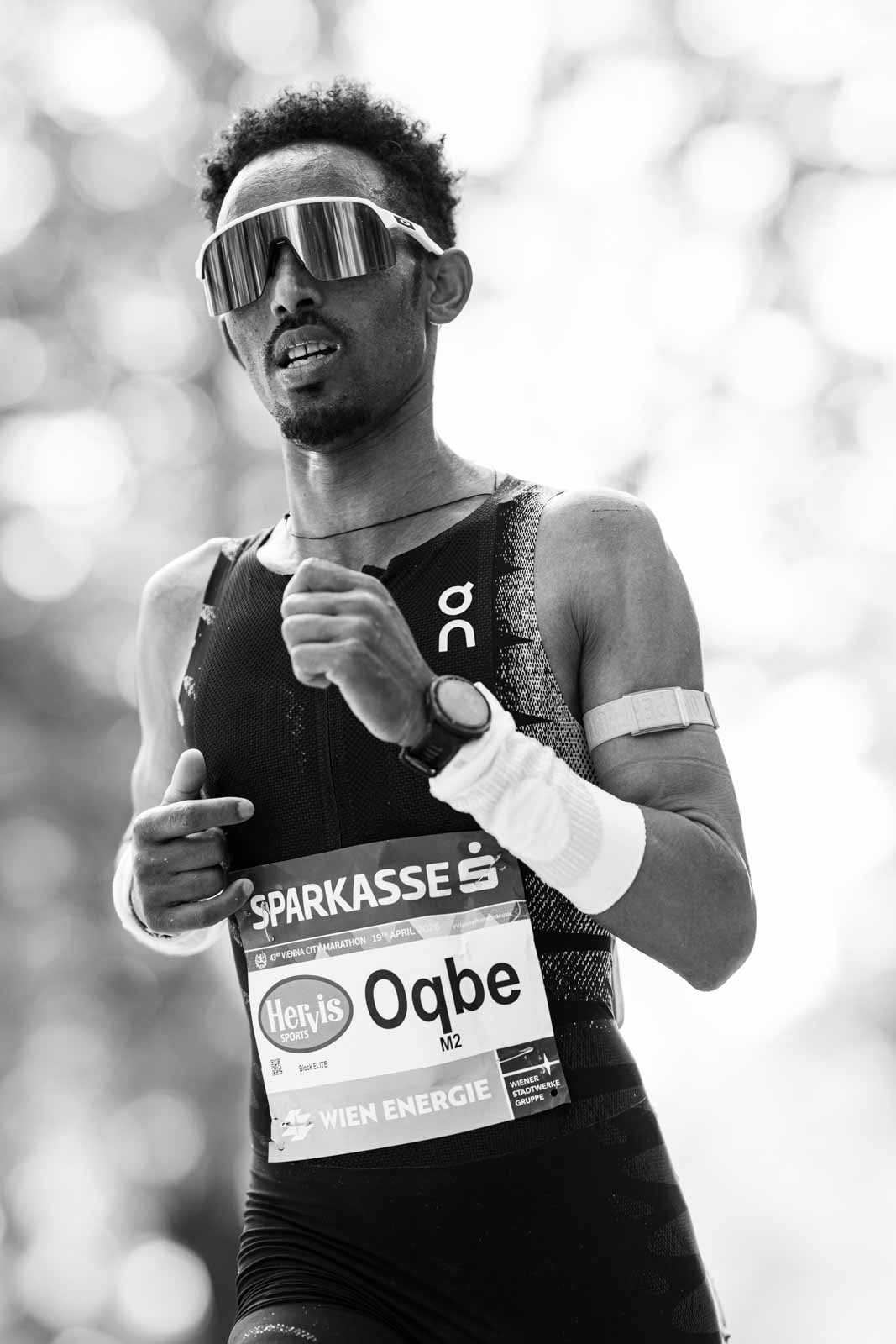 Close-up portrait of marathon runner Oqbe with sunglasses at the Vienna City Marathon — black and white photography by Peter Scholz