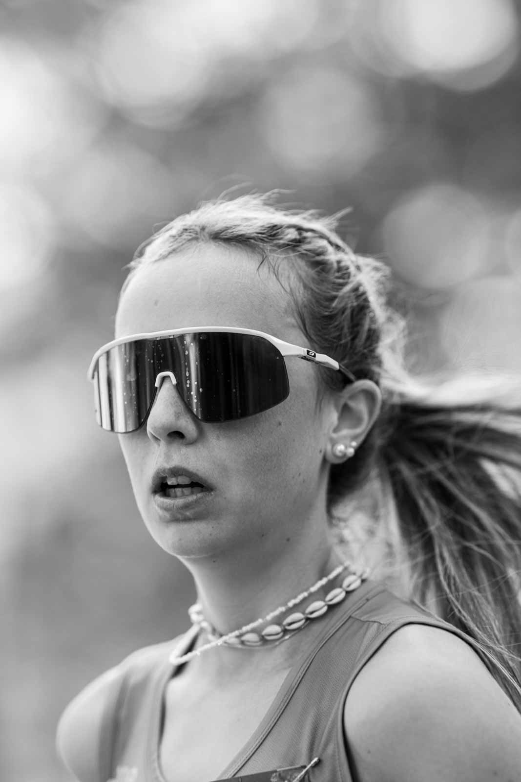Young female runner with sport sunglasses at the Vienna City Marathon — black and white portrait photography by schopho