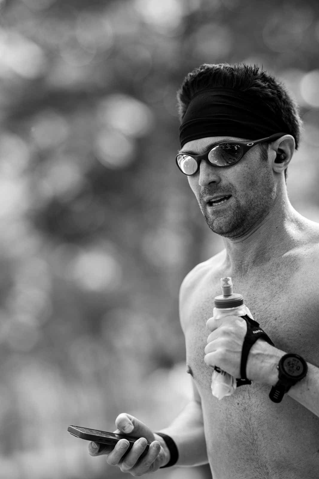 Marathon runner with headband and water bottle after the race — black and white editorial photography by Peter Scholz