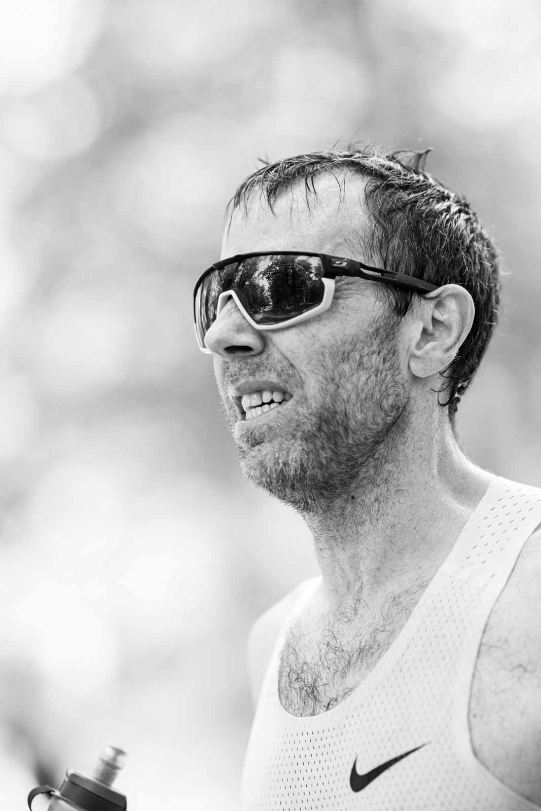 Marathon runner with sport sunglasses catching breath after the race — black and white fine art photography by Peter Scholz