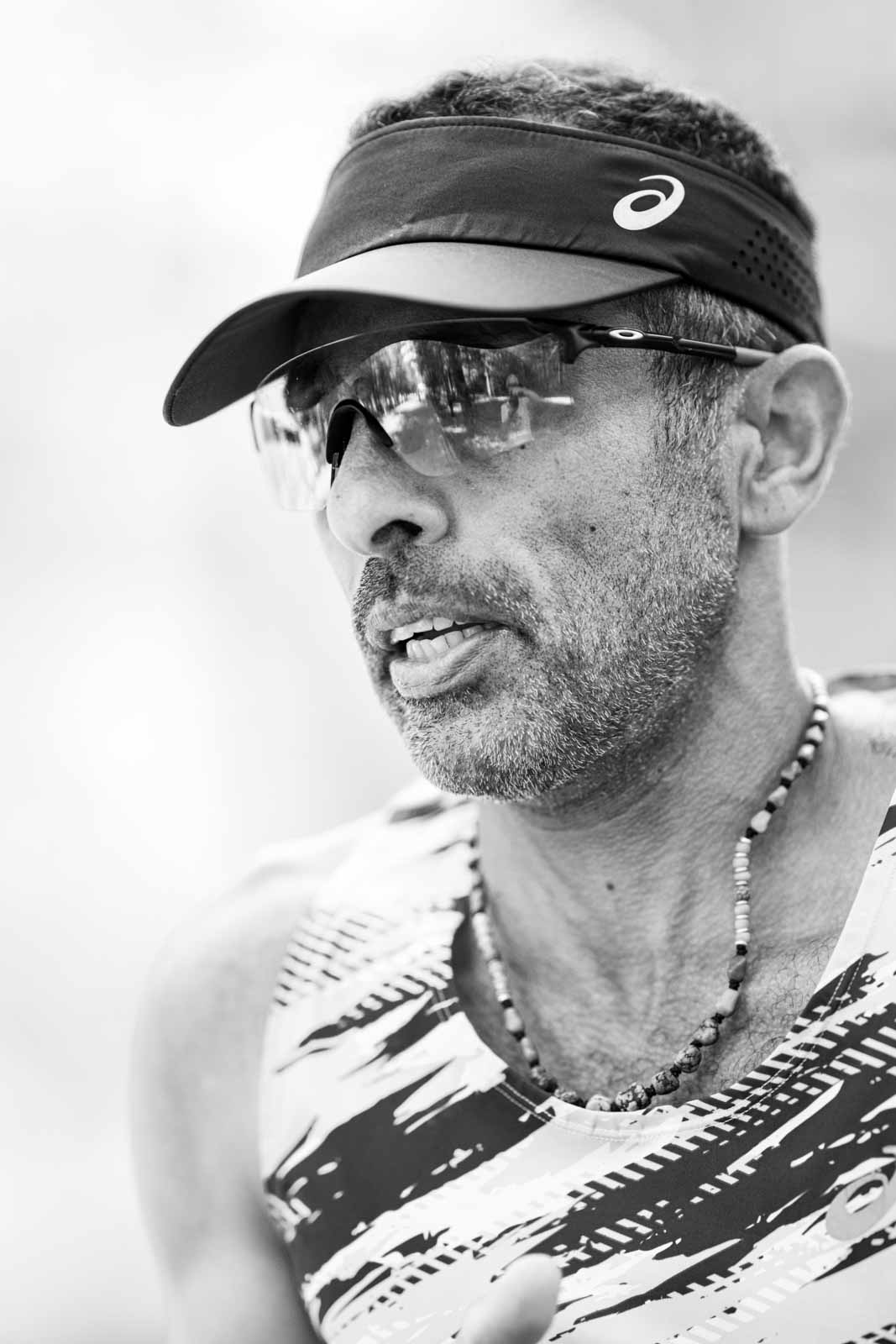 Marathon runner with visor and necklace in the Vienna Prater — black and white fine art photography by Peter Scholz
