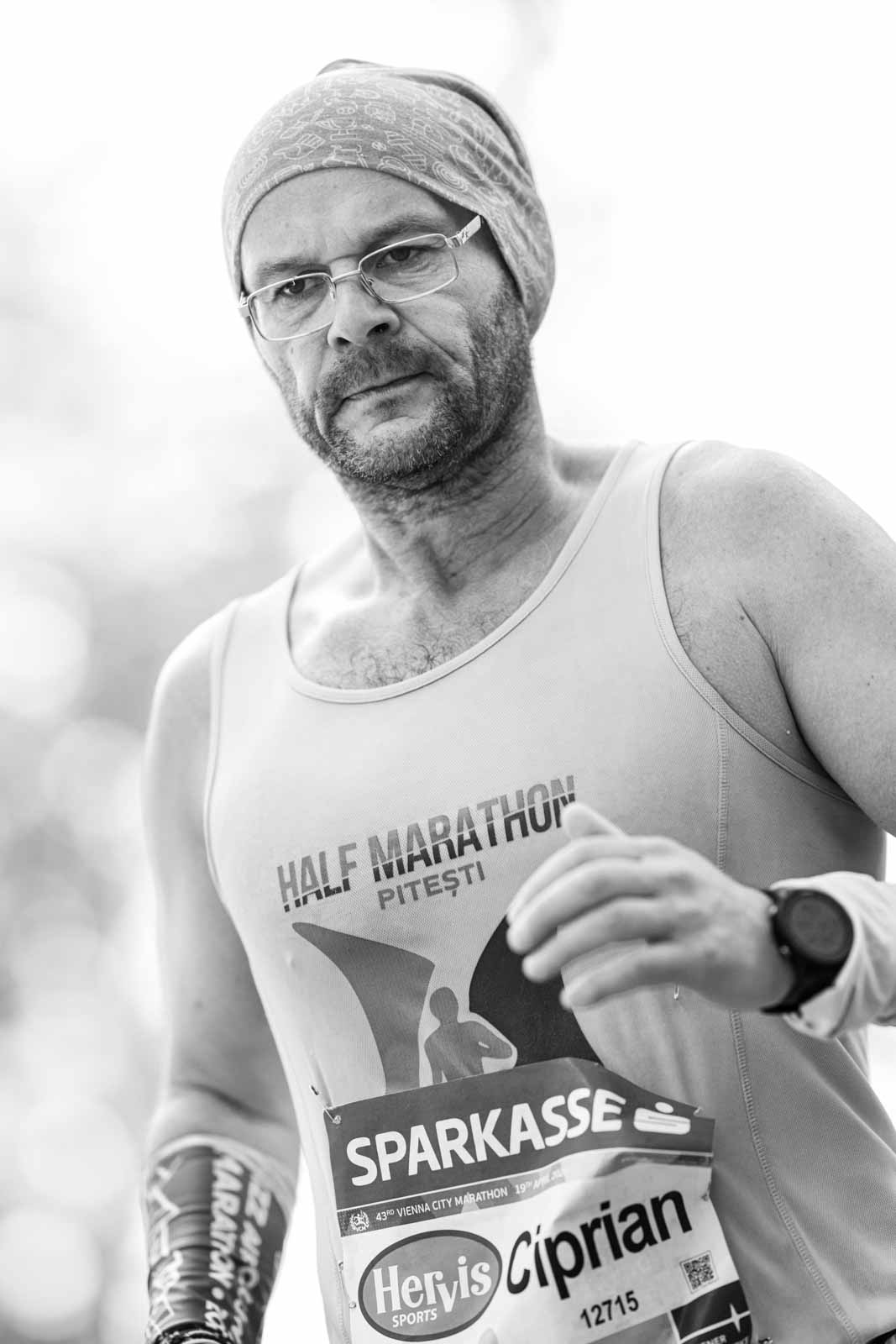 Marathon runner Ciprian wearing a Half Marathon Pitești shirt at the Vienna City Marathon — black and white portrait photography by Peter Scholz