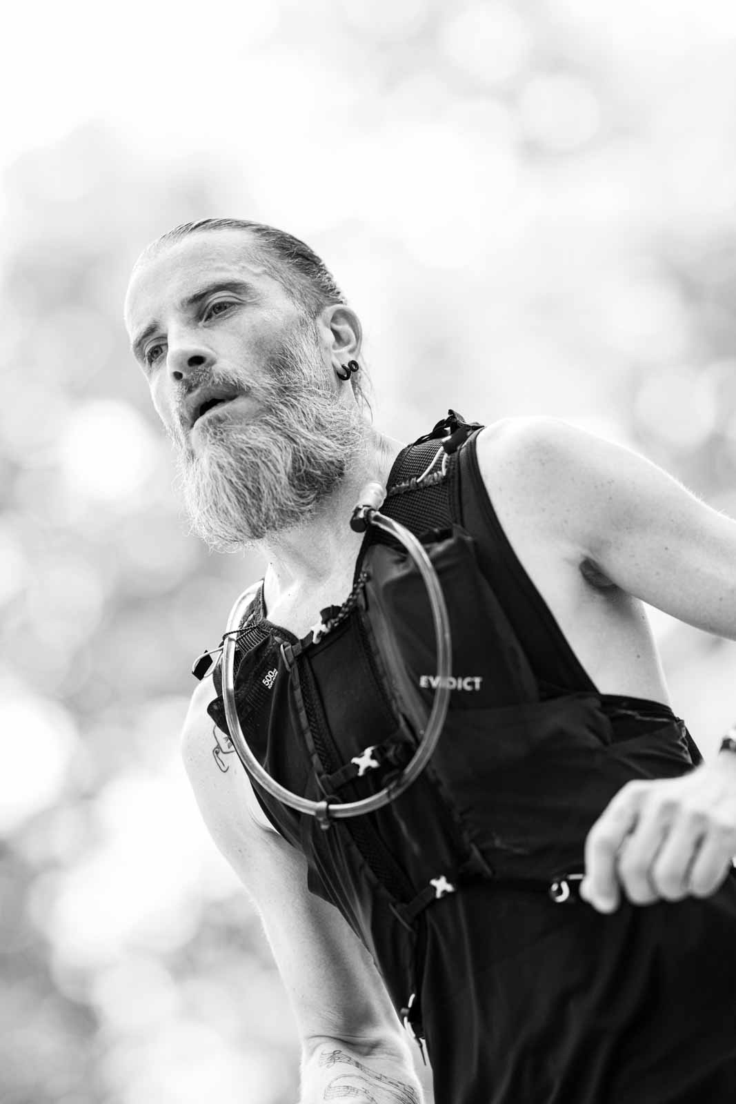 Marathon runner with grey beard and hydration vest in the Vienna Prater — black and white fine art portrait photography by schopho