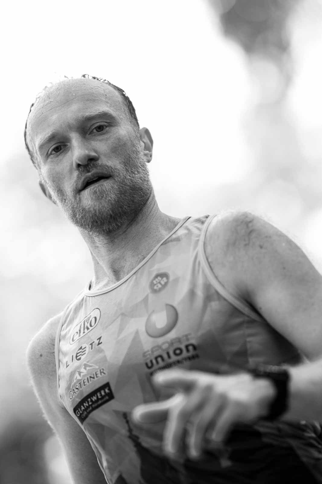 Close-up portrait of a focused Austrian marathon runner — black and white fine art photography by Peter Scholz