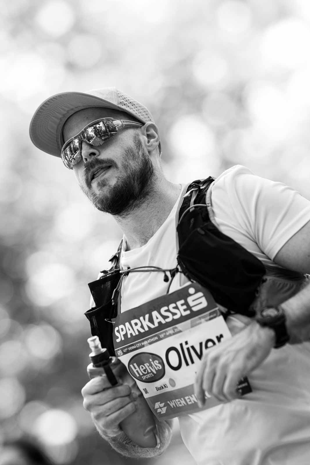 Trail-style marathon runner Oliver with cap and hydration vest at the Vienna City Marathon — black and white fine art photography by schopho