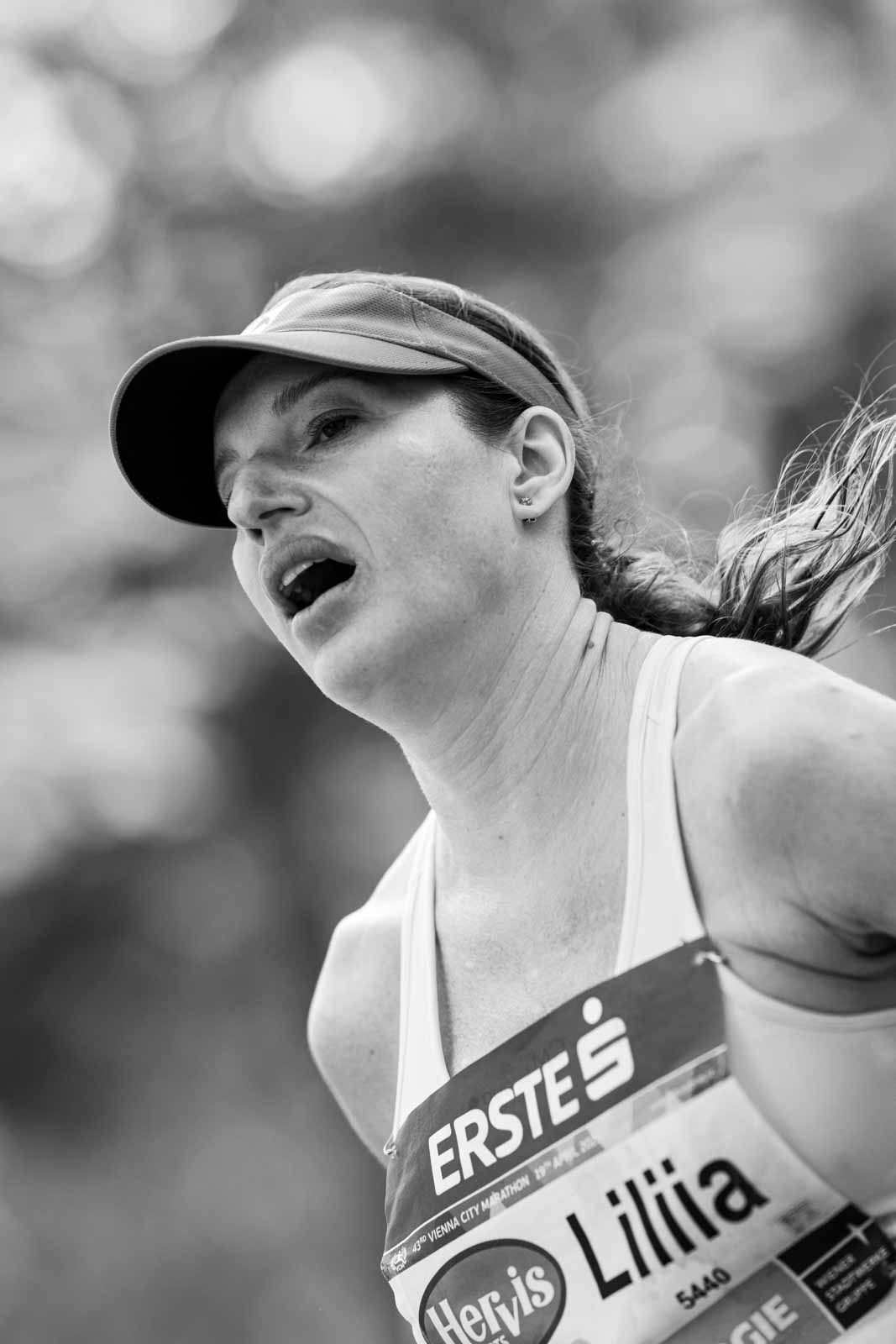 Female marathon runner Liliia in full effort with open mouth at the Vienna City Marathon — black and white editorial photography by Peter Scholz