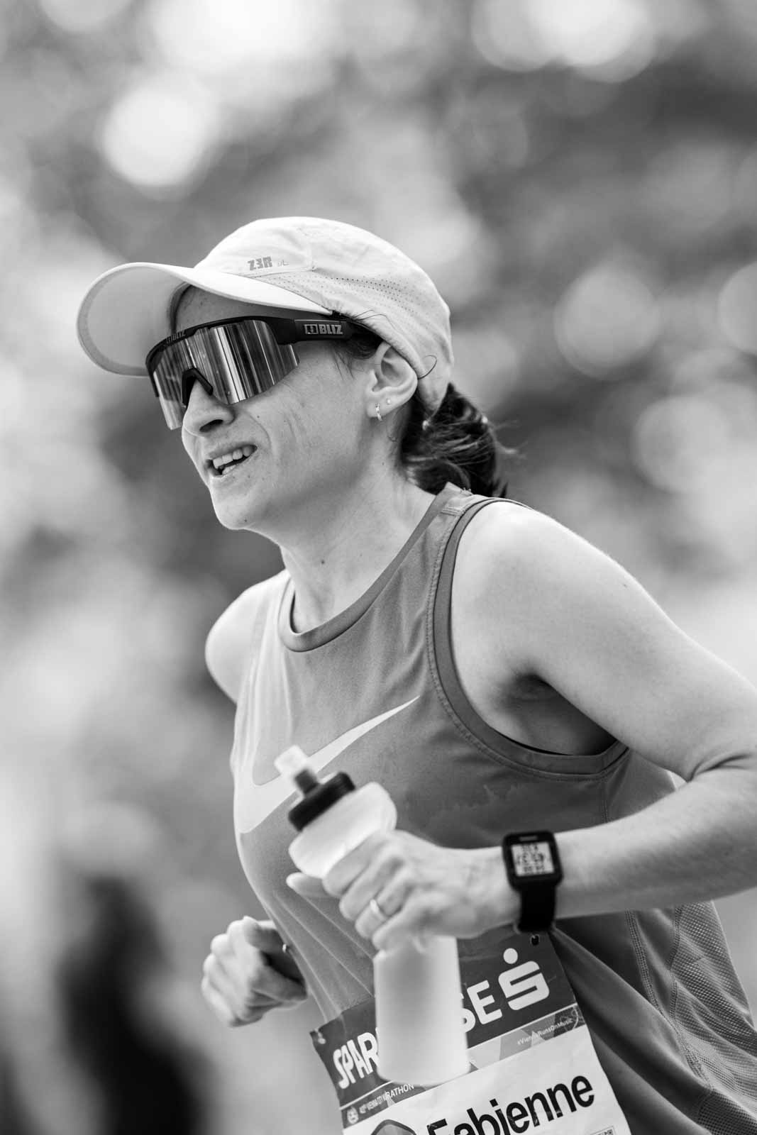 Female marathon runner Fabienne with sport sunglasses and water bottle in the Vienna Prater — black and white fine art photography by Peter Scholz
