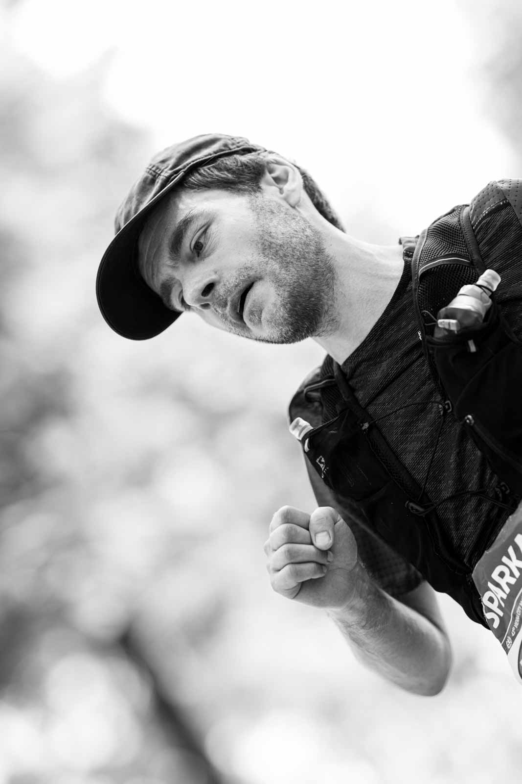 Trail-style marathon runner with cap and hydration vest in the Vienna Prater — black and white fine art photography by Peter Scholz