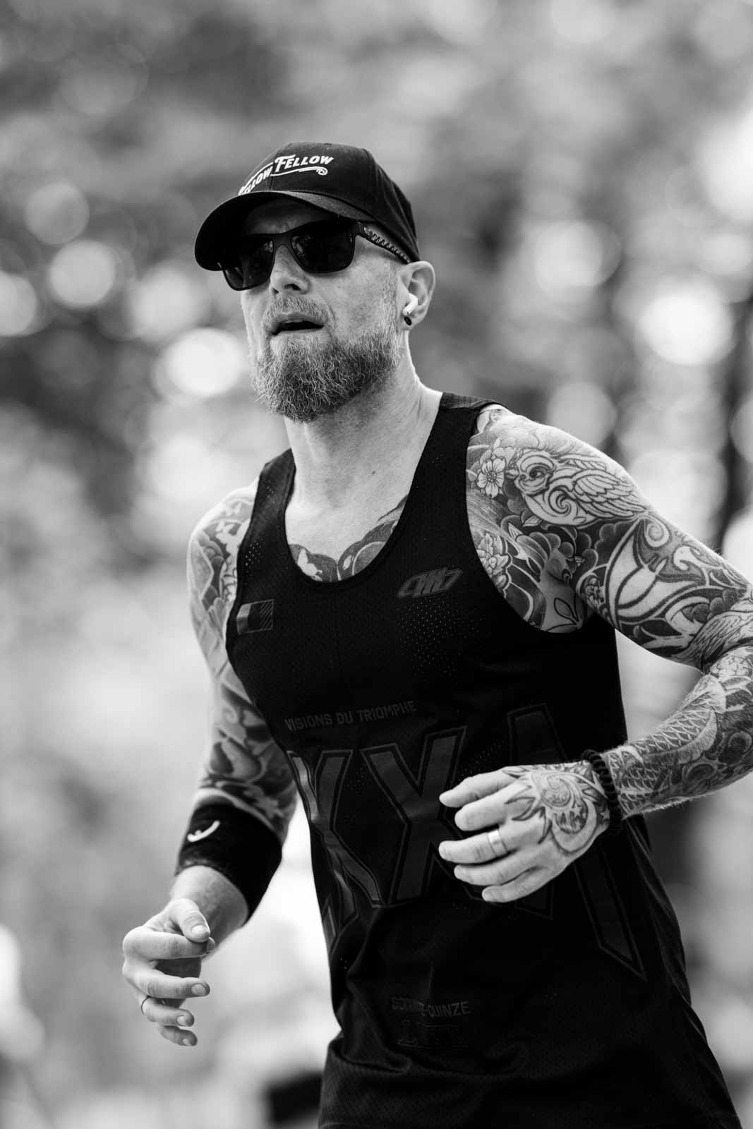 Tattooed marathon runner with Yellow Fellow cap at the Vienna City Marathon — black and white fine art photography by schopho