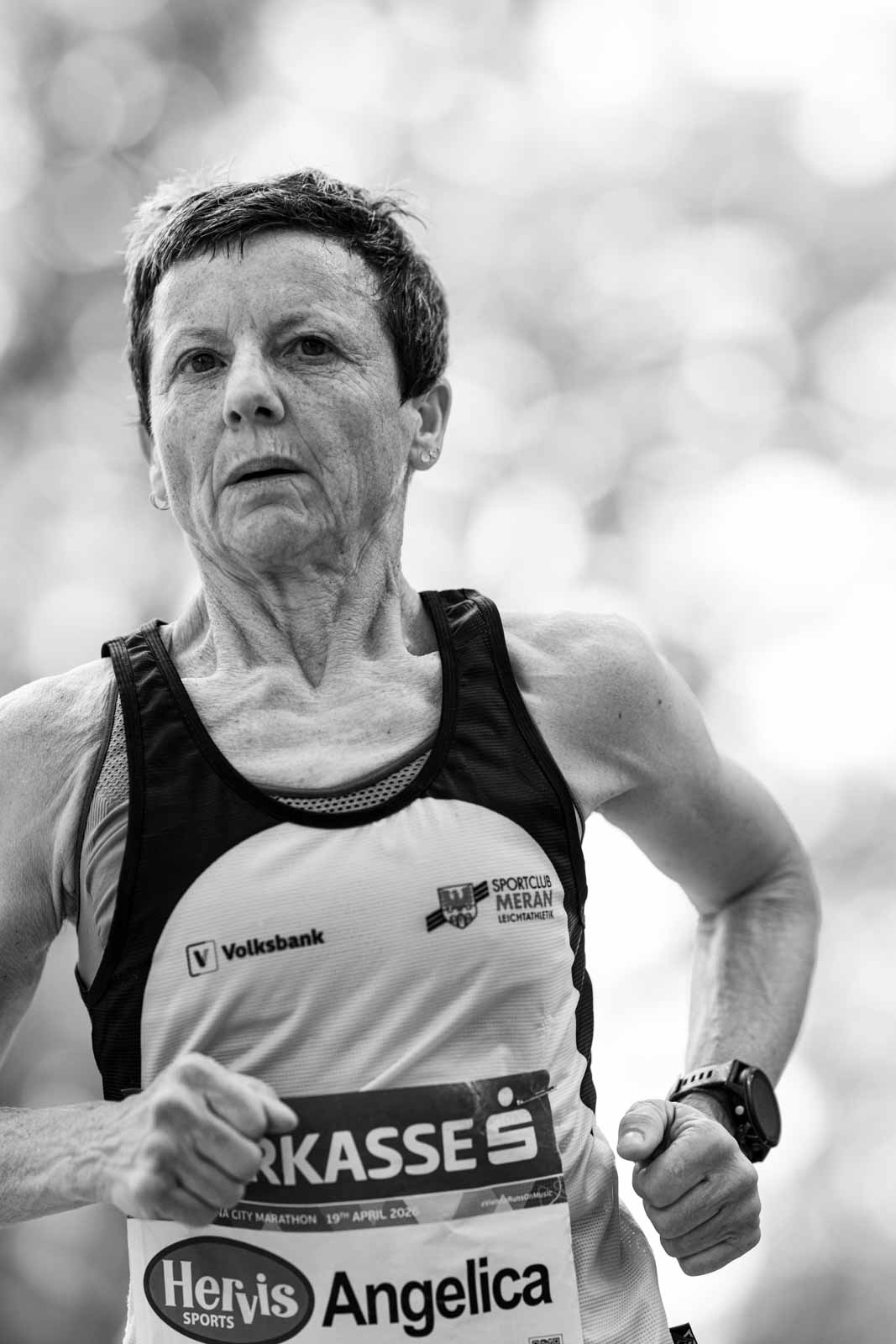 Senior female marathon runner Angelica from Sportclub Meran in full effort — black and white portrait photography by Peter Scholz