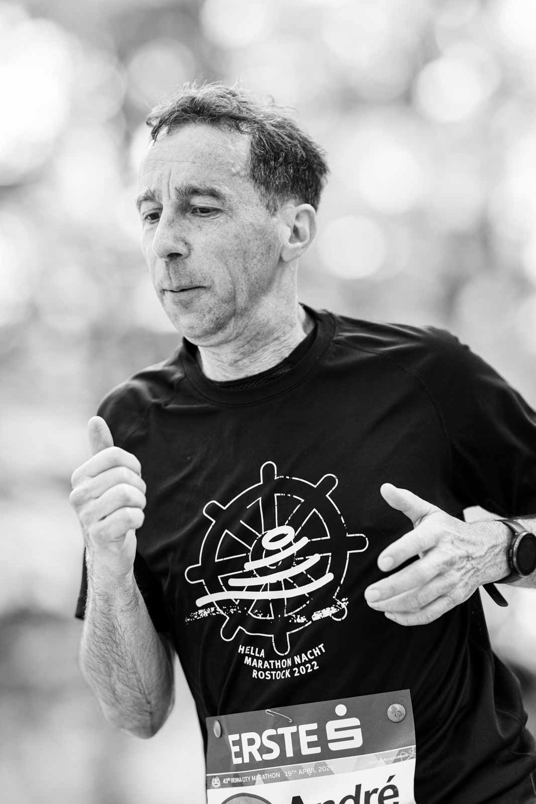 Marathon runner André with Hella Marathon Nacht Rostock 2022 shirt — black and white editorial portrait photography by Peter Scholz
