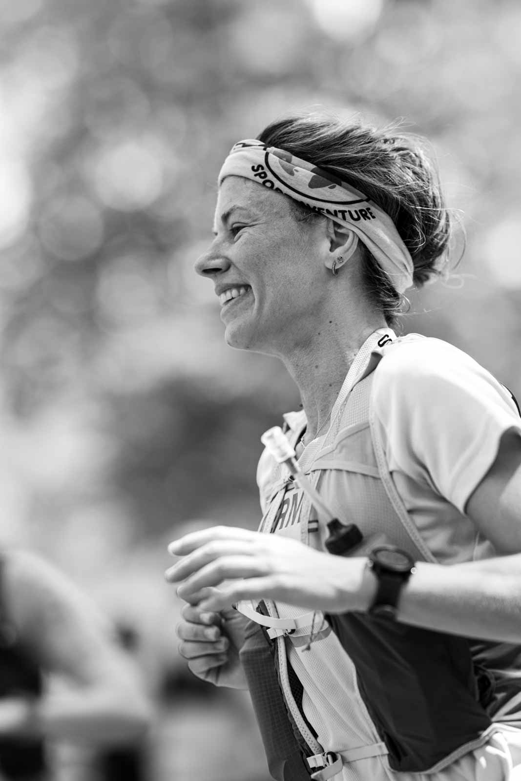 Smiling female marathon runner with Sport Adventure headband in the Vienna Prater — black and white editorial photography by schopho
