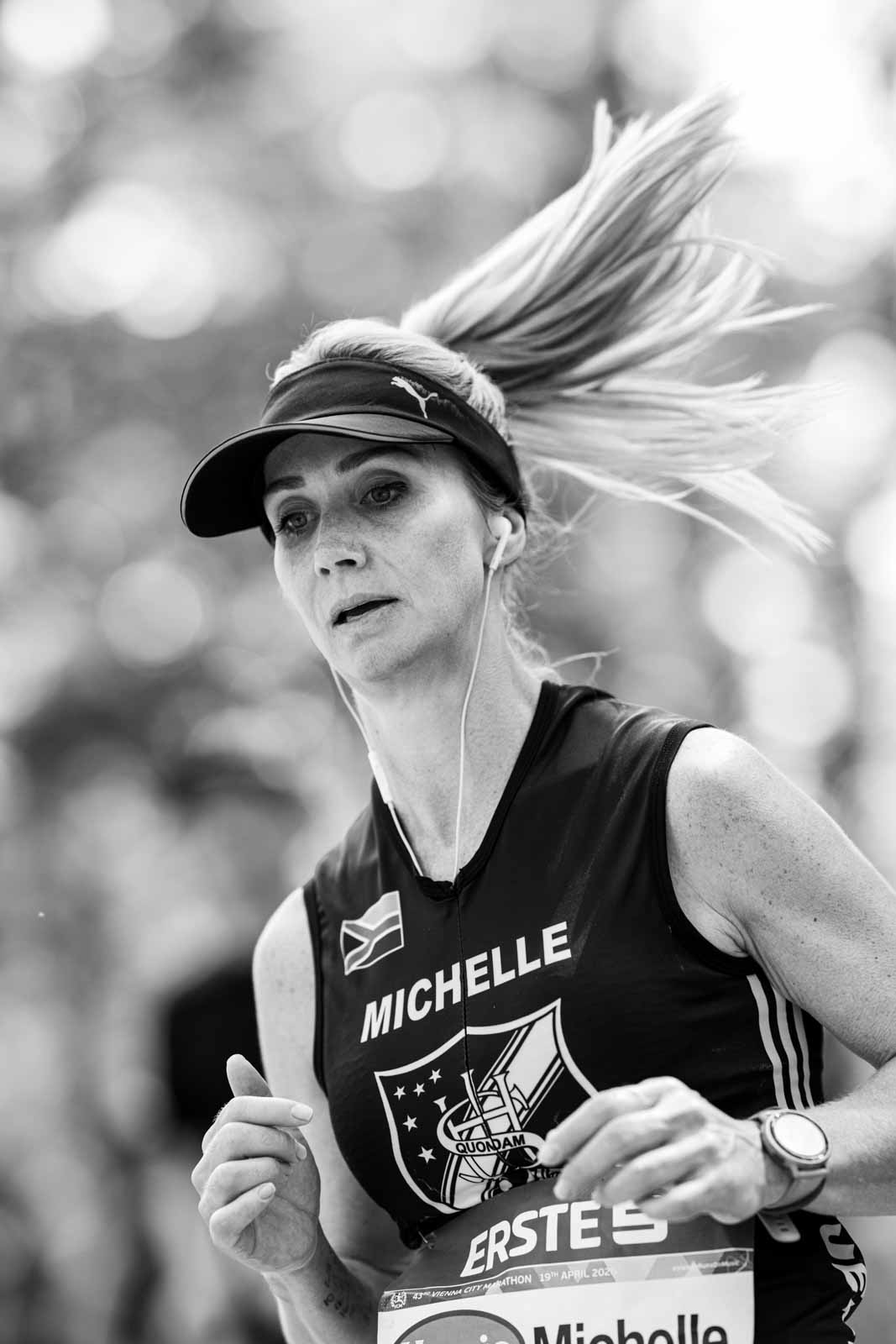 Female marathon runner Michelle with flowing blonde ponytail and Puma visor — black and white fine art photography by schopho