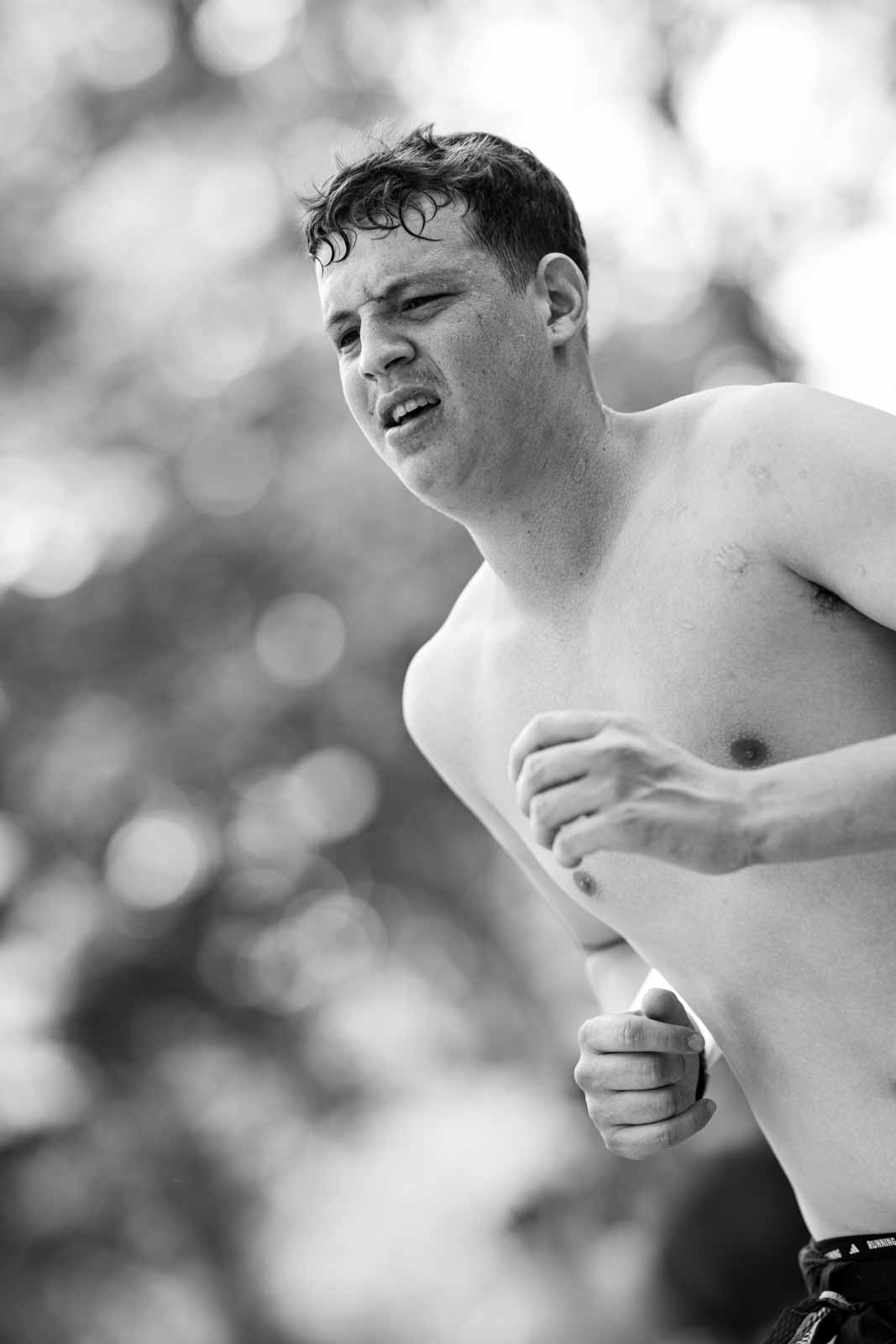 Shirtless young marathon runner in full effort at the Vienna City Marathon — black and white fine art photography by Peter Scholz