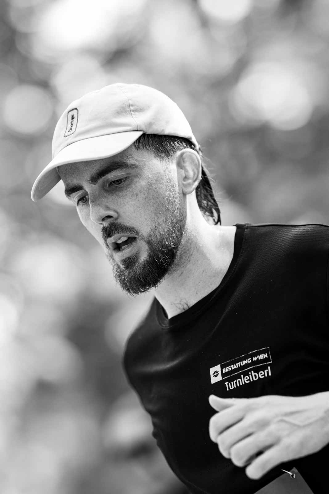 Marathon runner with Quiksilver cap and Bestattung Wien Turnleiberl shirt — black and white fine art photography by schopho